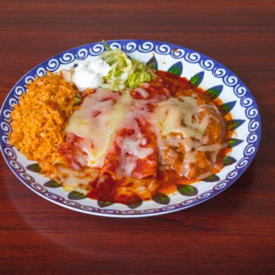 Enchiladas topped with melted cheese, served with rice, guacamole and sour creme.
