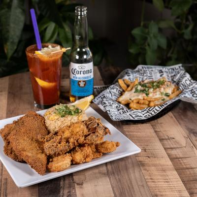 Asian Cajun Platter alongside loaded fries and Michelada cocktail.