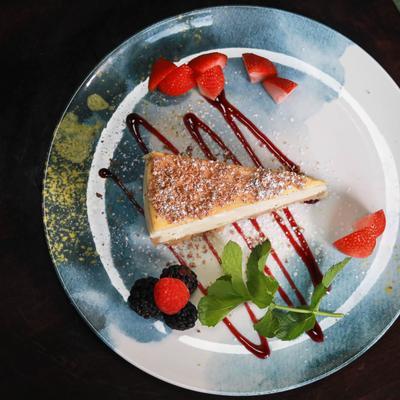 Cheesecake plate, garnished with berries and mint, top view.