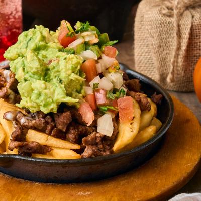 Steak fries topped with guacamole and pico de gallo.