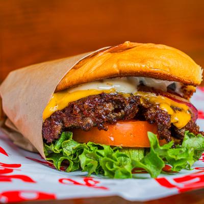Single Cheeseburger with lettuce, tomato and onion.