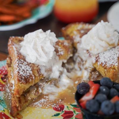 French toast topped with whipped cream and powdered sugar, served with mixed berries.