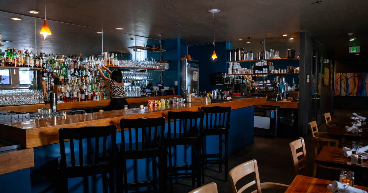 Interior with a bar area, bar seating, and a bartender