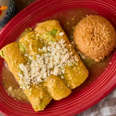 Three enchiladas topped with green salsa and fresh cheese, served with rice.