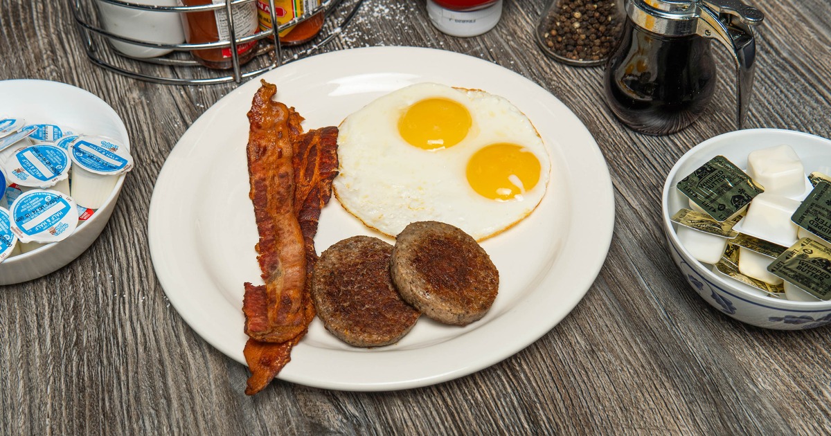 Bacon eggs and sausage patties on a plate