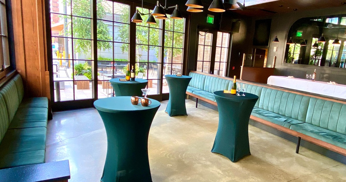 Cocktails tables arranged in a room with banquette sofas