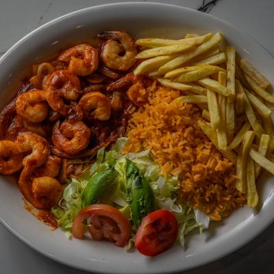 Spicy shrimp, with rice, salad, and fries.