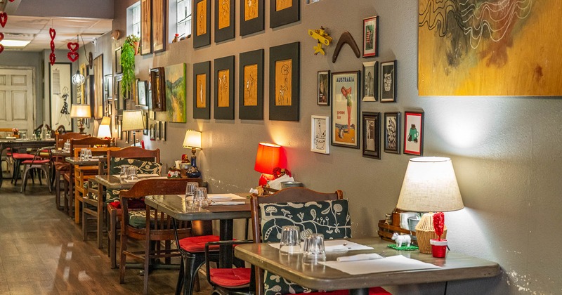 Interior, tables and chairs all lined up with pictures on the wall