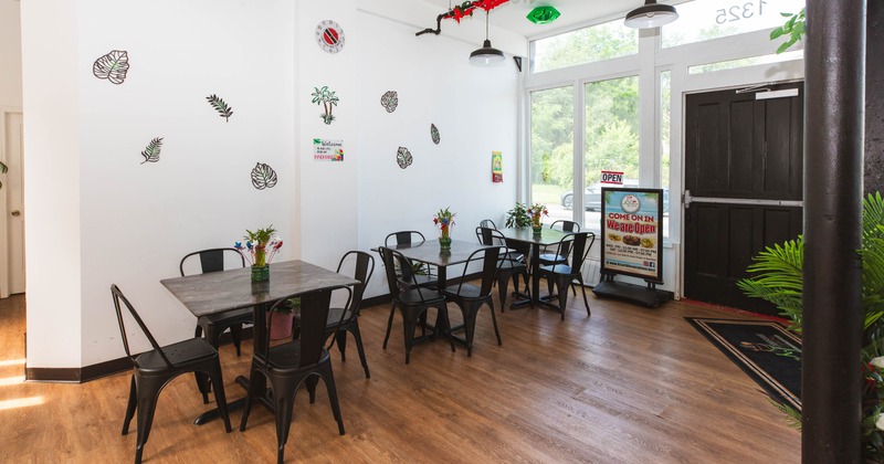 Interior view of a restaurant with black tables and chairs