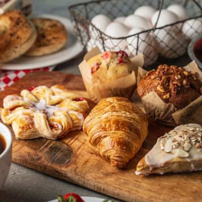 Wooden board with various breakfast pastries, served.