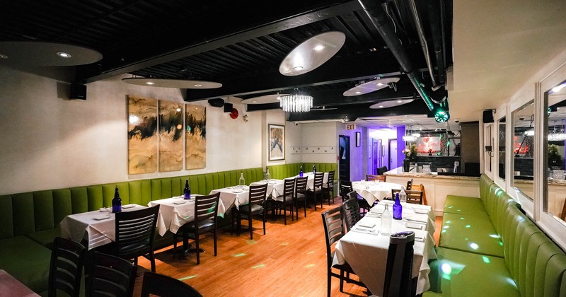 Inside, dining area with long banquette seating and wooden chairs, tableware, pictures