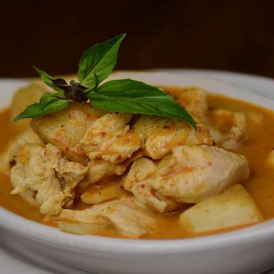Chicken curry with basil leaves on top.