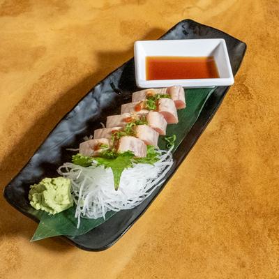 Yellowtail sashimi, with salad and dipping sauce.