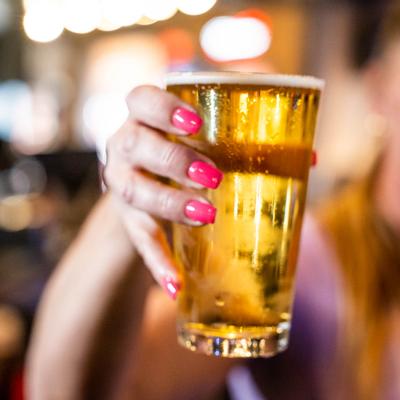 A hand holding a glass of beer