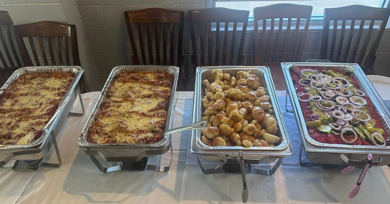 Catering buffet with trays of food served in aluminum foil steam pans