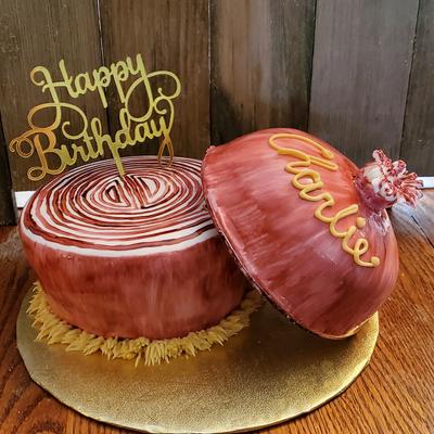 Round cake resembling a wooden log, with Happy Birthday topper and a lid.