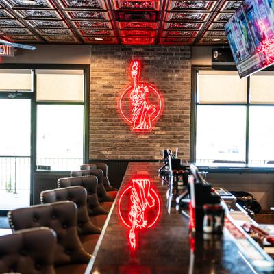 Restaurant's interior with  red neon sign representing Statue of Liberty.