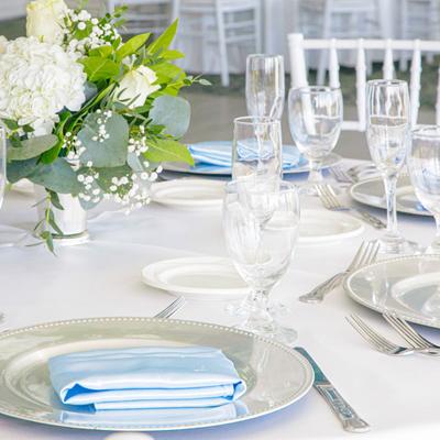 Fully set table, with napkins, plates, utensils, and glasses.