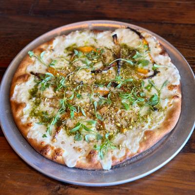 Roasted butternut squash pizza, pistachio pesto, white sauce, fresh mozzarella, micro cilantro.