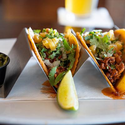 Al Pastor tacos and green salsa, close up.