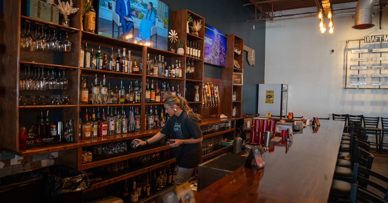 Bar area, bartender sorting glassware