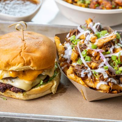 Juicy double cheeseburger paired with loaded fries on a tray.
