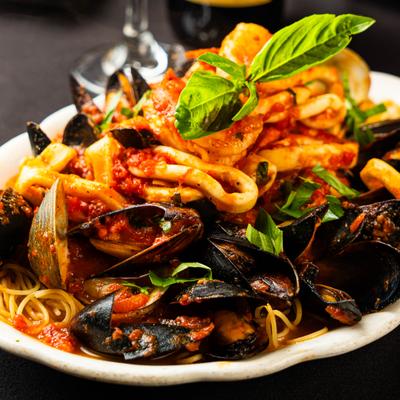 Seafood pasta with tomato sauce and basil garnish.