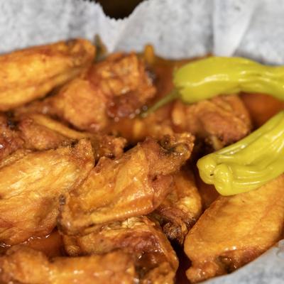 Fried chicken wings served with whole pepperoncini peppers.