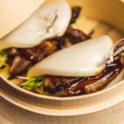 Roast duck, scallions, cucumbers, and hoisin sauce in a steamed bun