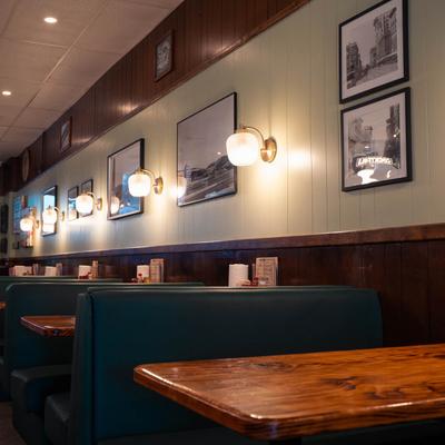 Dining booths along a wall decorated with framed vintage photographs.