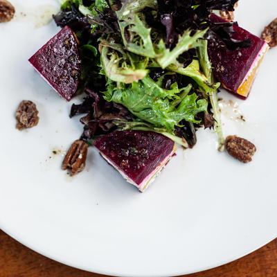 a salad that contains beet and goat cheese on a white plate in Charlotte nc