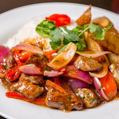 Stir fried beef, with onion, tomatoes, bell peppers, ginger, yellow chili, rice, and potatoes.