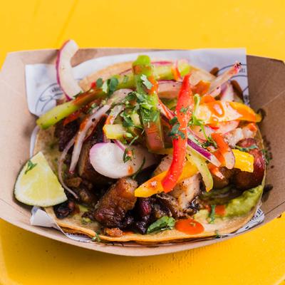Chicharron taco topped with fresh radish, onion, and colorful peppers.