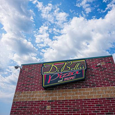 Exterior, Di Bella's sign on a building under a bright blue sky with scattered clouds.