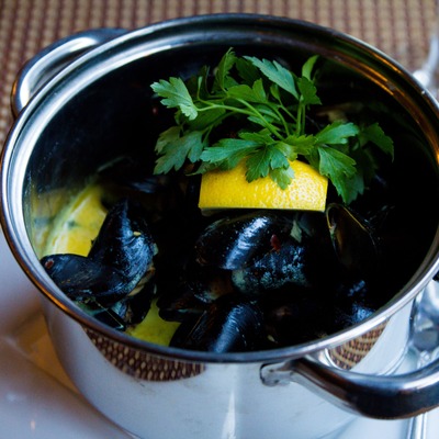 Steamed mussels garnished with parsley and lemon.