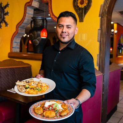 Server carrying two plates of food.