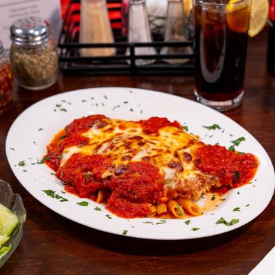 Chicken Parm Dinner with a  salad, drinks, and condiments on a table.