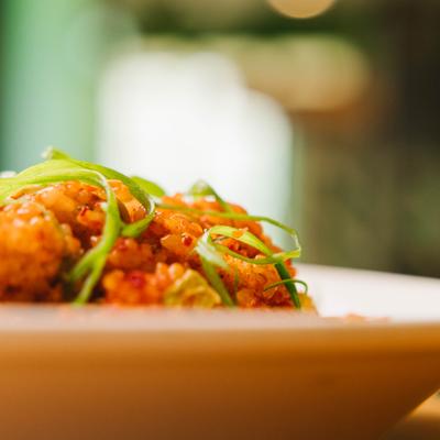 Crispy fried bites garnished with green onions, close up.