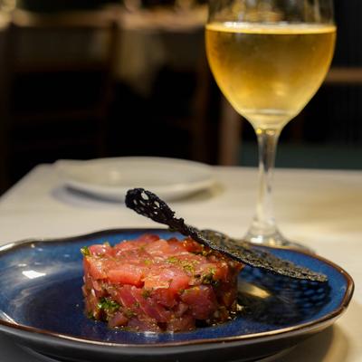 Tuna tartare with a glass of white wine.