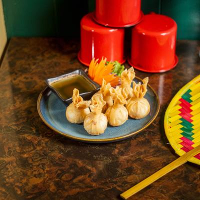 Crispy fried Thai pastry pouches filled with savory minced meat, served with dipping sauce.