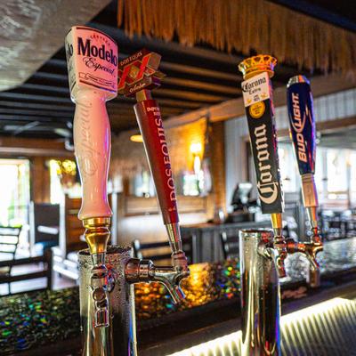 Four draft beer tap handles on a bar counter background.