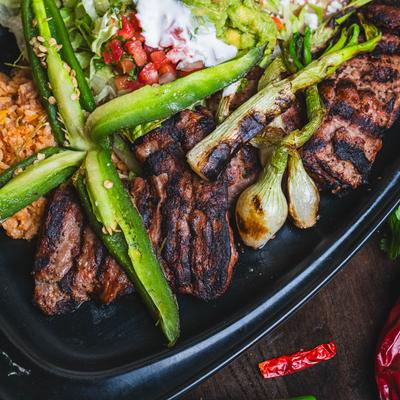 Marinated and grilled steak, served with rice, beans, guacamole, pico, and sour cream.
