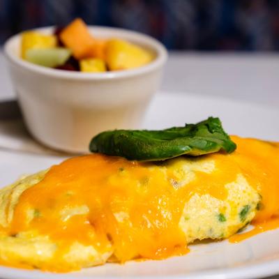 Omelette topped with avocado and melted cheese.