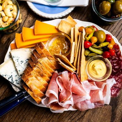 Overhead view of a charcuterie plate with assorted cured meats, cheeses, and crackers.