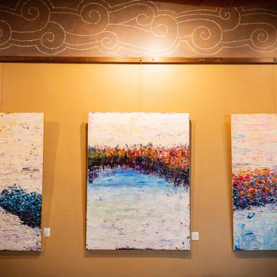 Abstract paintings displayed on the coffeehouse wall.