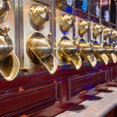 Vintage-style brass coffee bean dispensers, close-up.