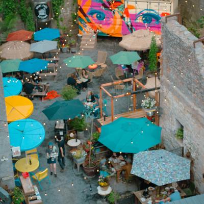 Outdoor patio featuring unique seating vignettes, colorful umbrellas and string lights.