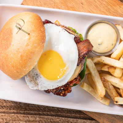 Bacon cheeseburger, with sunny side up egg, and fries.