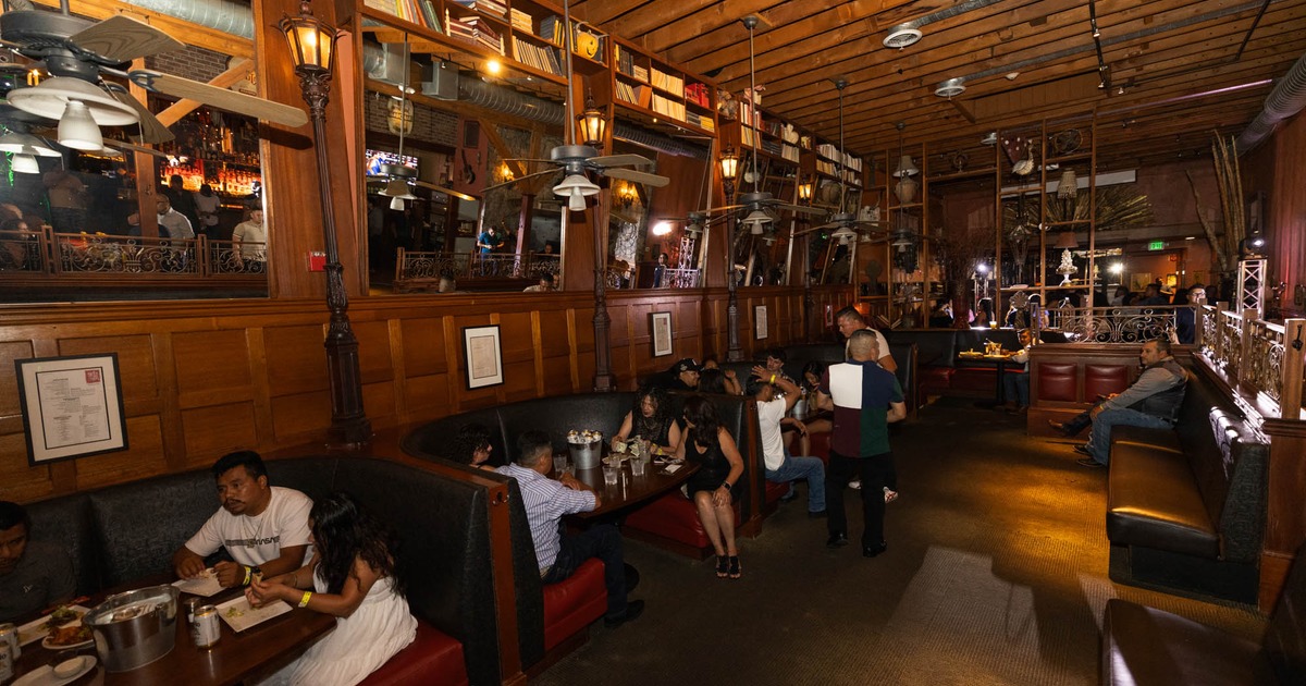 Interior with wooden panels and ceiling, Patrons sit in cozy booths, enjoying meals