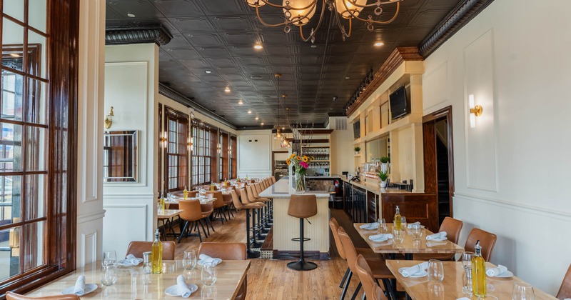 Interior, restaurant entrance, dining area and bar, large windows with wooden frames